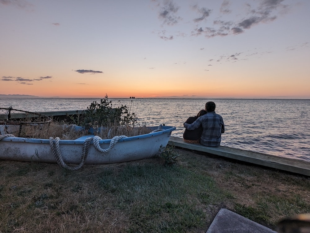A couple on the beach enjoy sunset during their weekend getaways in Seattle