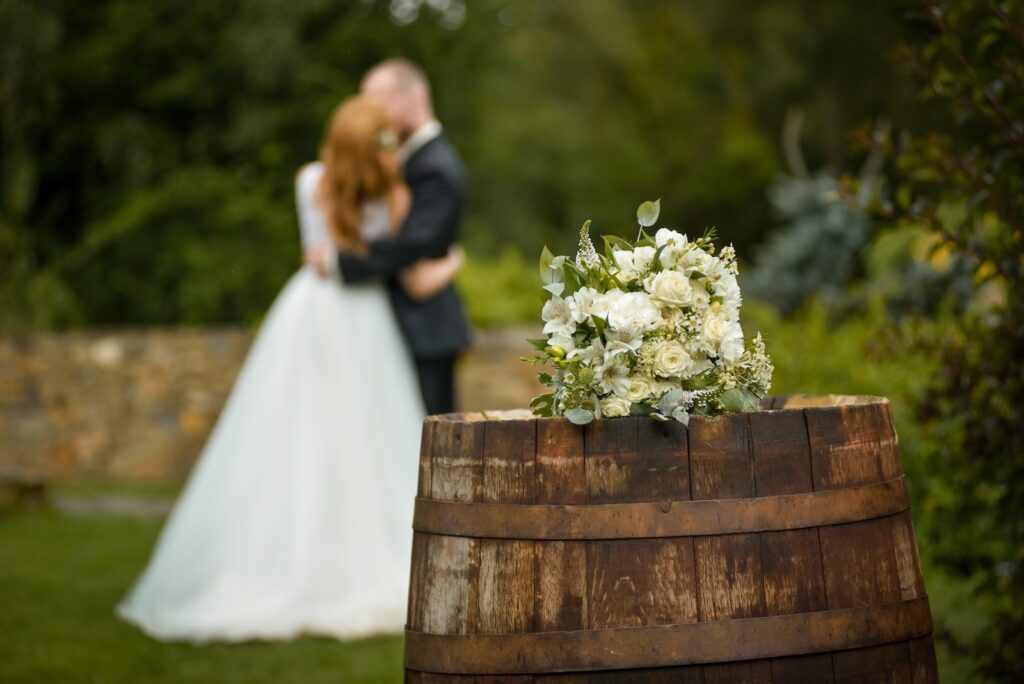 Wedding bouquet on a barrel against the background of the bride and groom eloping in Kentucky