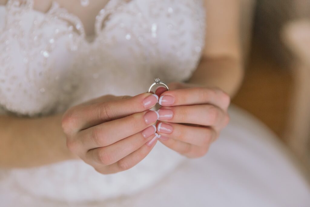Woman holding a wedding ring in her wedding dress before her Hocking Hills Elopement