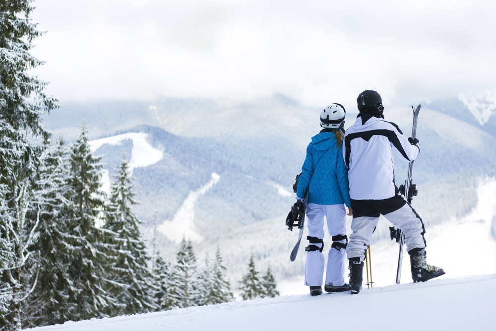 A couple enjoying skiing in New Hampshire, one of the best things to do in the White Mountains in winter