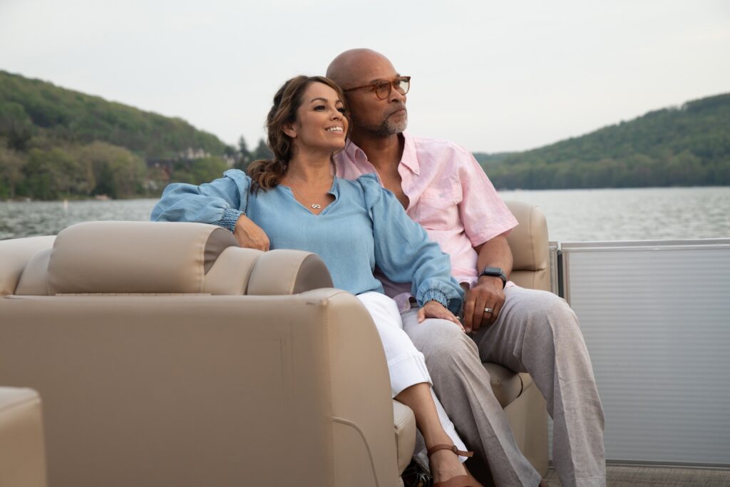 One of the best things to do in Deep Creek MD is explore the lake on a pontoon boat ride. Photo of a happy couple enjoying a boat ride on the lake