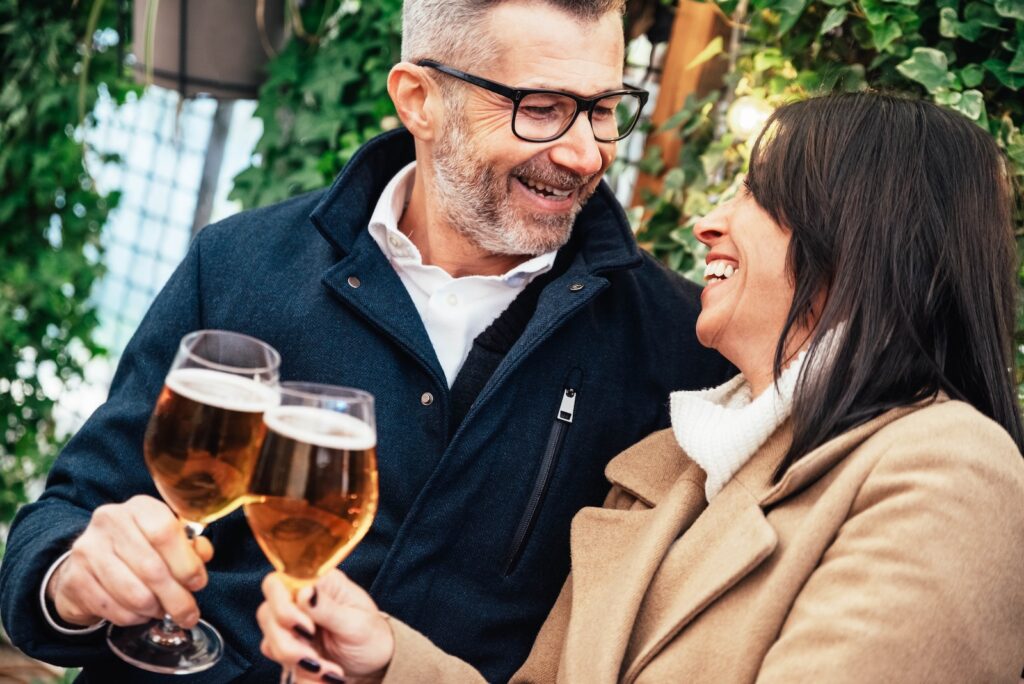 Mature couple having fun drinking beer at cafe bar restaurant, one of the best things to do in Pennsylvania for couples