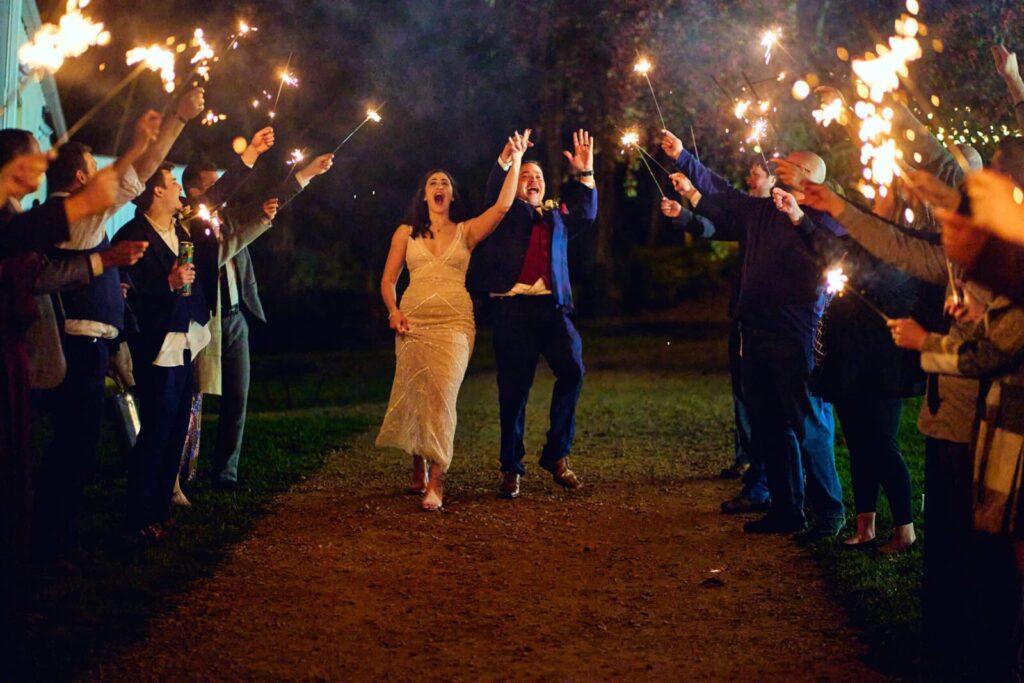 Best Wedding Exit Ideas, couple leaving their reception to a row of sparklers