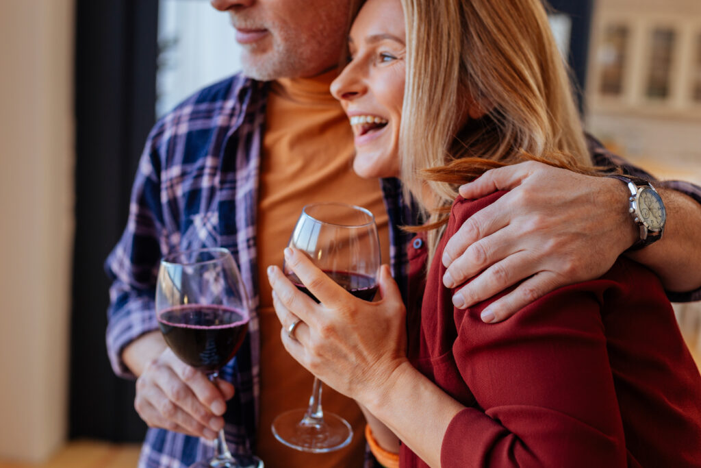 Couple on romantic getaways in Wisconsin hugging and drinking wine.