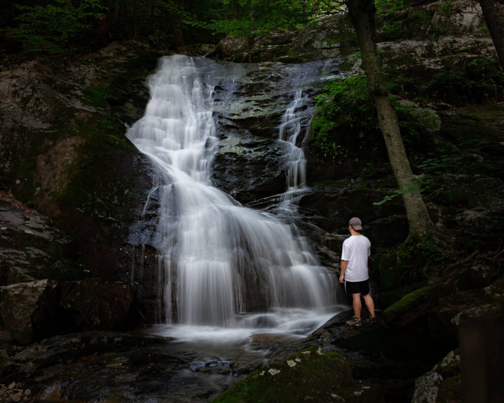 Man standing at the base of Crabtree Falls, VA