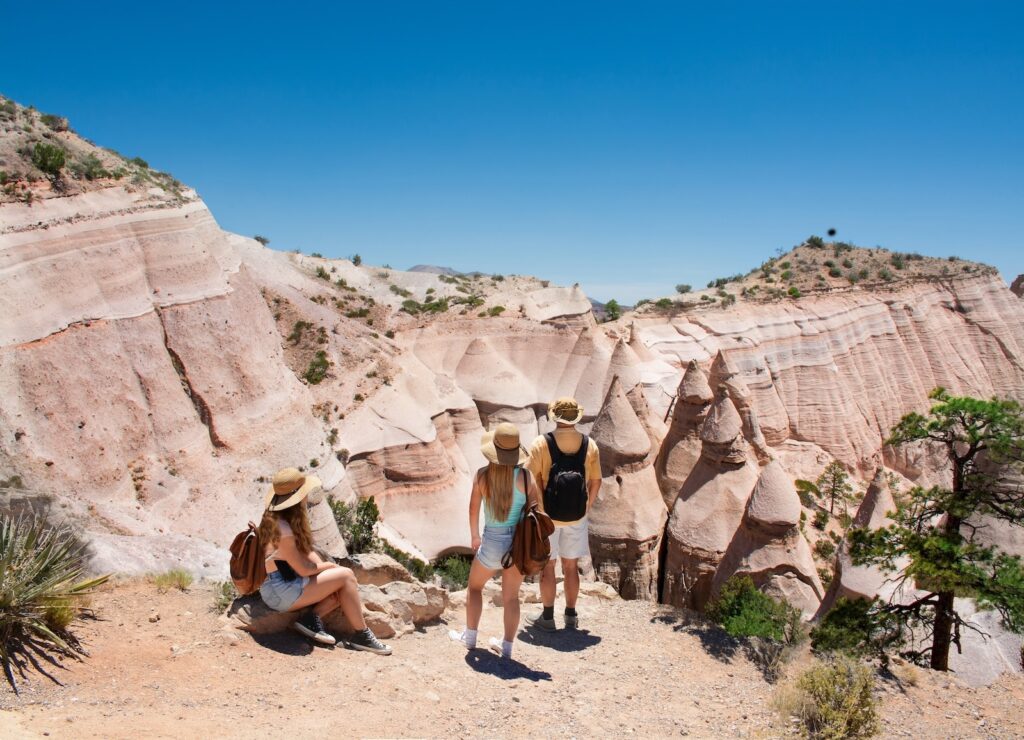 Visiting Kasha-Katuwe Tent Rocks National Monument is one of the coolest things to do in Santa Fe with kids. This family takes a break to view the rock formations.