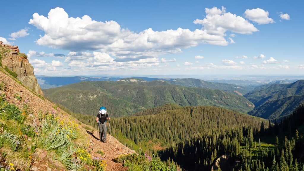 Man hiking on one of the best hikes near Durango with mountain scenery