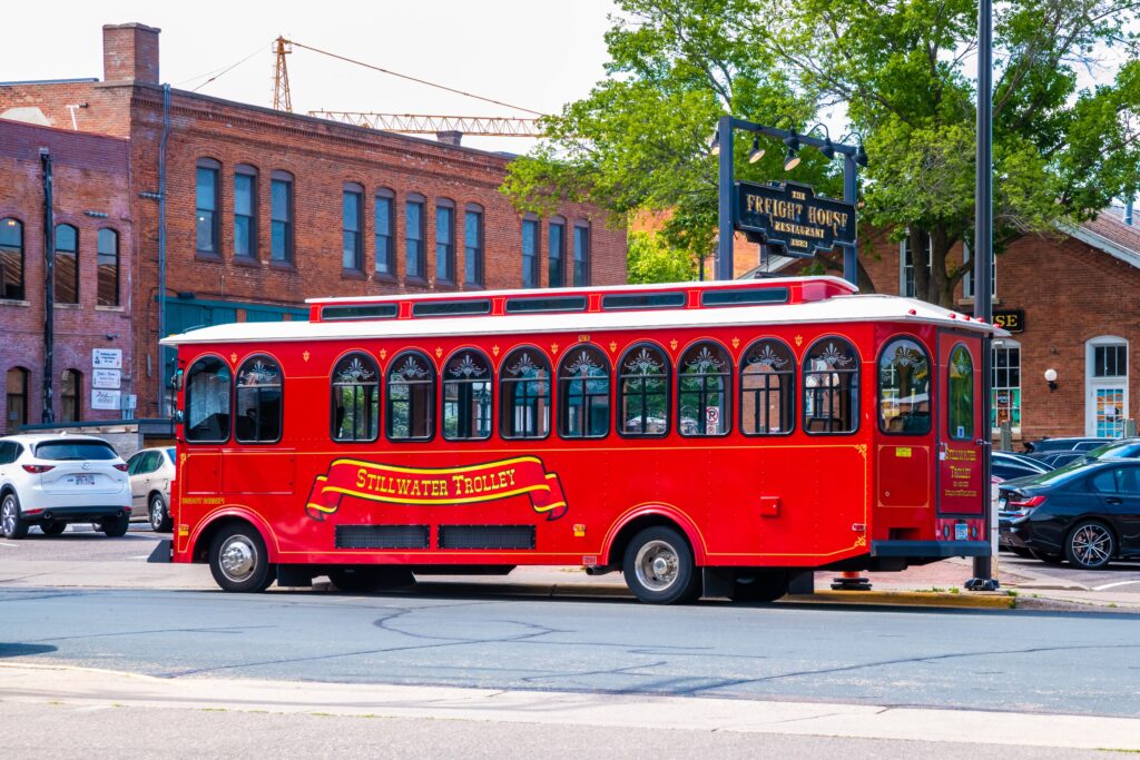 Red Stillwater Trolley in front of brick building in Stillwater MN.