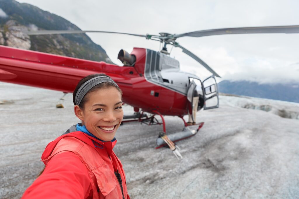 Happy tourist taking selfie on helicopter tour excursion, one of the most memorable Juneau Tours to take this summer