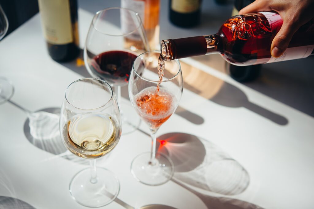 Three glasses of wine, rose being poured. Enjoy a tasting at Fletcher Bay Winery