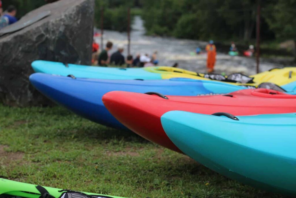 Kayaks lined up along a river for people to enjoy Wisconsin River kayaking.
