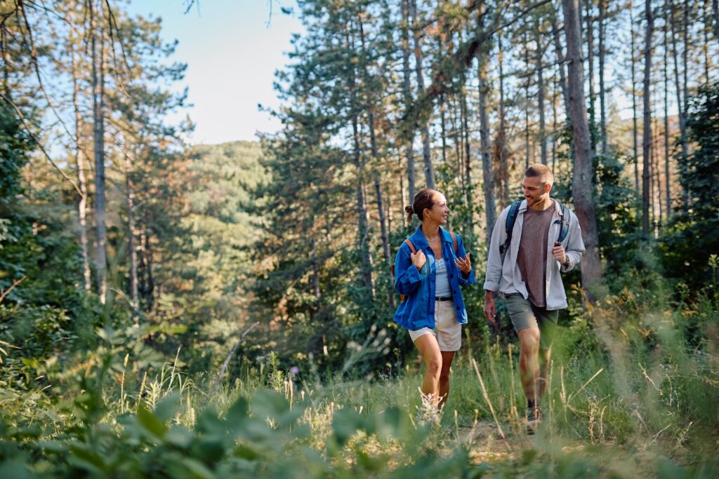 Couple of hikers with backpacks walking in a forest path in the Mad River Valley Vermont