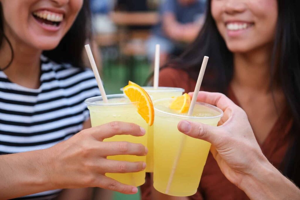 Two girls toasting with an orange drink at one of the rooftop bars in Durham.