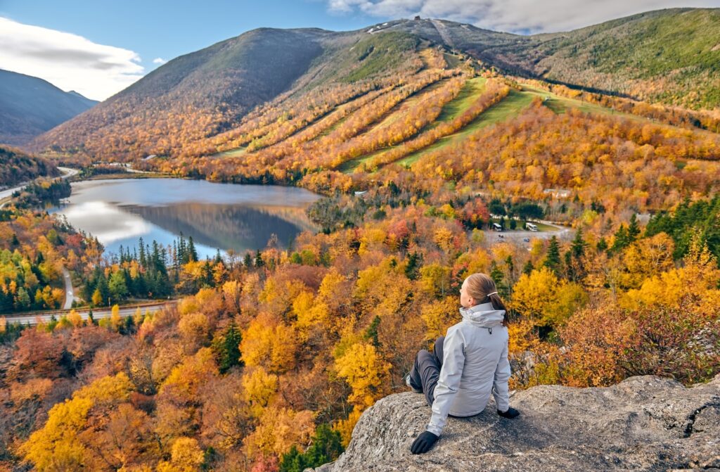 Woman hiking at Artist's Bluff in autumn in Franconia Notch State Park.