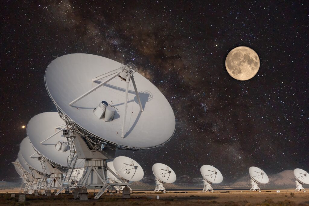 Very Large Array New Mexico at night, radio telescope in y-formation, moon and stars in dark sky