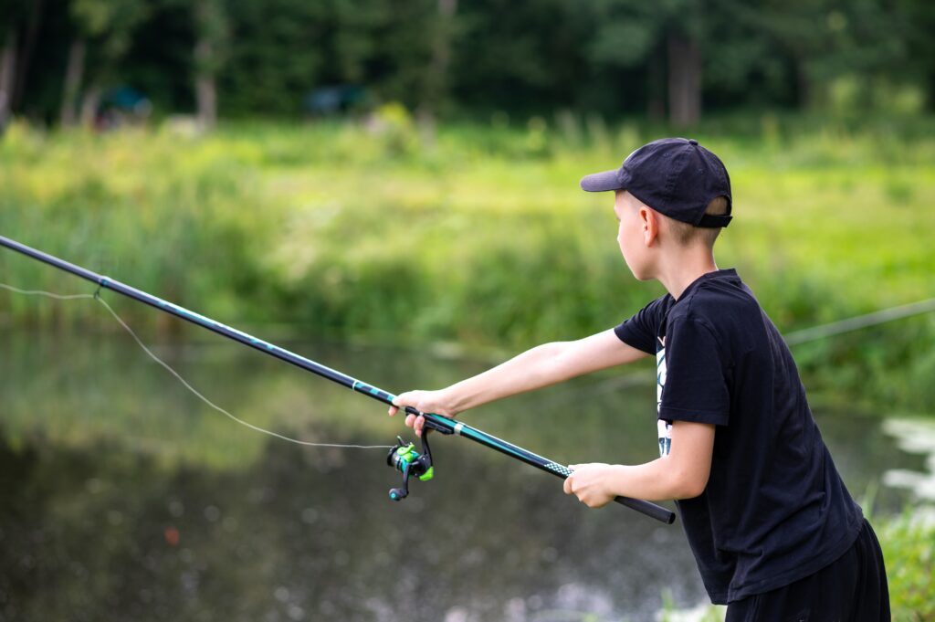 Teenage boy casts fishing line at Crescent Lake in Oregon