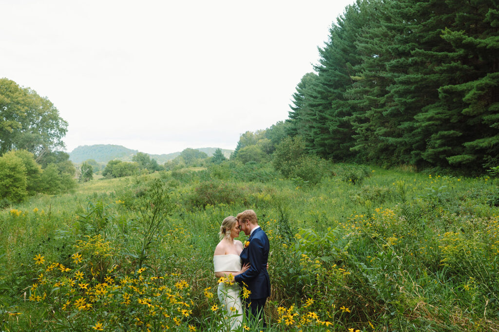 Bride and groom in the meadow with wildflowers at Round Barn Farm, one of the best nature wedding venues in Minnesota.