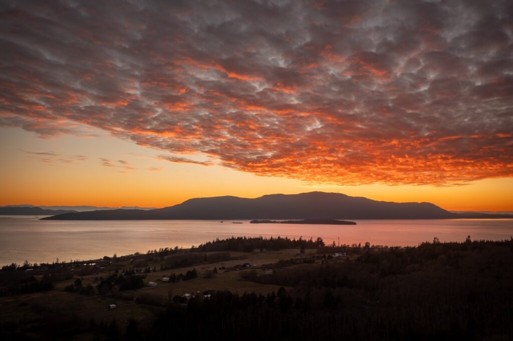 Discover the best things to do in Friday Harbor this Fall, a beautiful sunset over one of the San Juan Islands