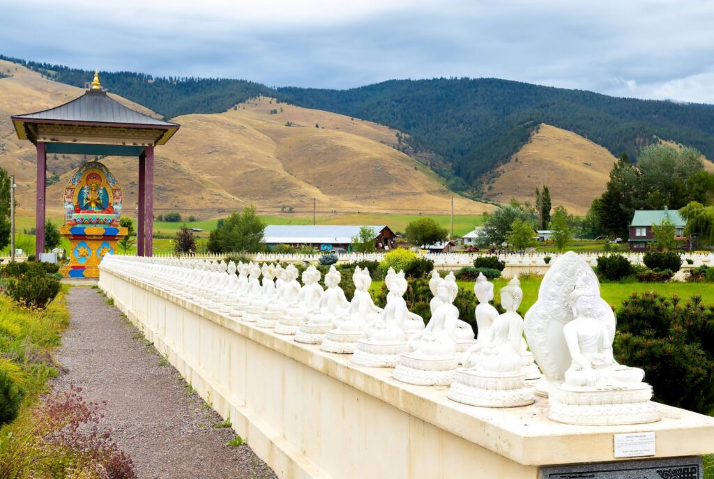 The Garden of the Buddhas in Arlee, Montana, one of the unique things to do in Montana, featuring white statues in a mountain setting.