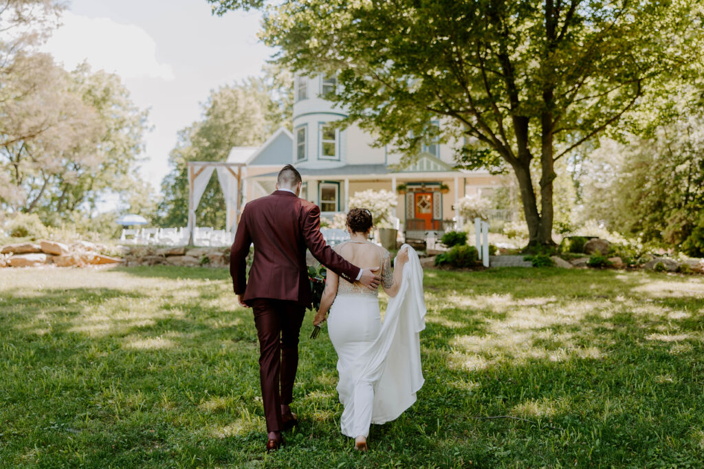 Bride and groom walk back toward our Historic Inn after their wedding ceremony at one of the best small wedding venues in PA