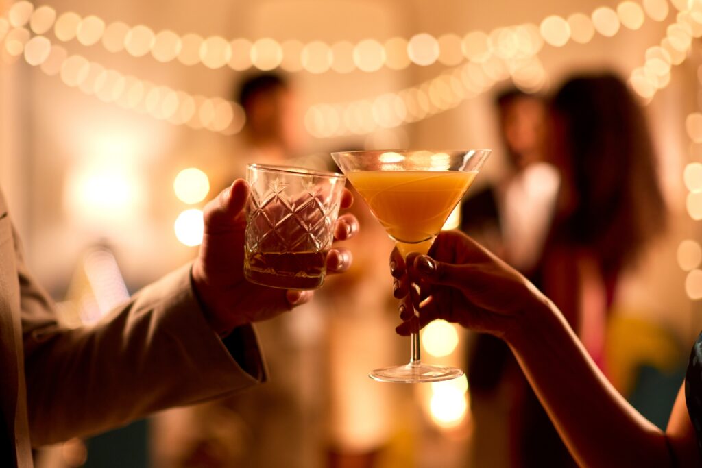 close up photo of couple toasting with cocktails at wedding welcome party